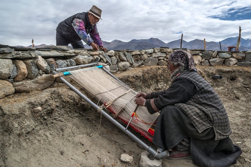 Tsering Dondap and his wife Yama chat as she weaves a carpet on the bank of Pangong lake in Spangmik village, around 60 kilometres southeast of Tangste town