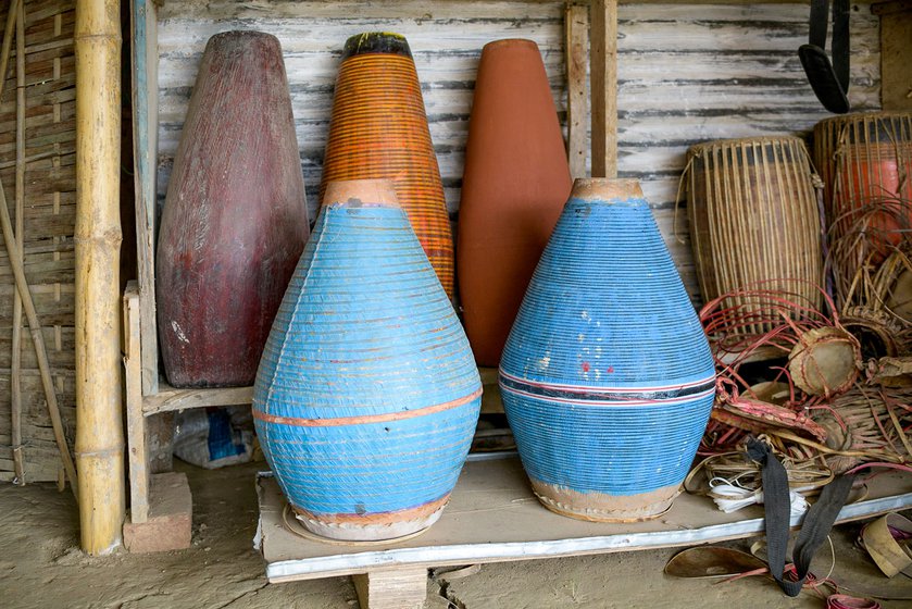 Right: Bengali khols (in blue) are made from clay and have a higher pitch than the wooden Assamese khols (taller, in the back)