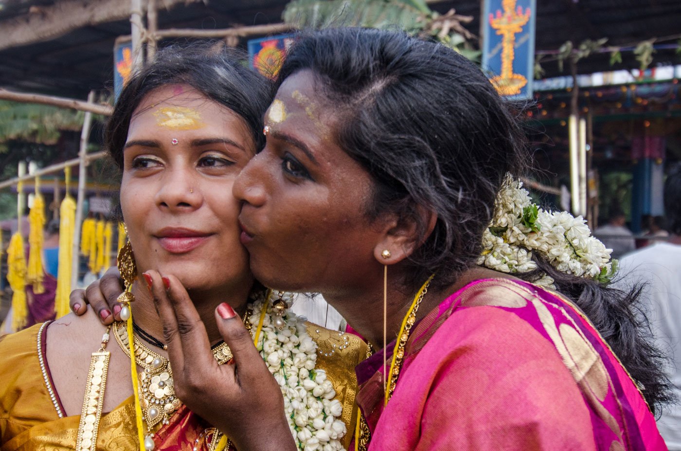 Once they’ve tied the knot, the aravanis rejoice. Pinky (right), in a gleeful moment, kisses her best friend and sister bride Mala. A transgender woman kisses another transgender woman on the cheek.