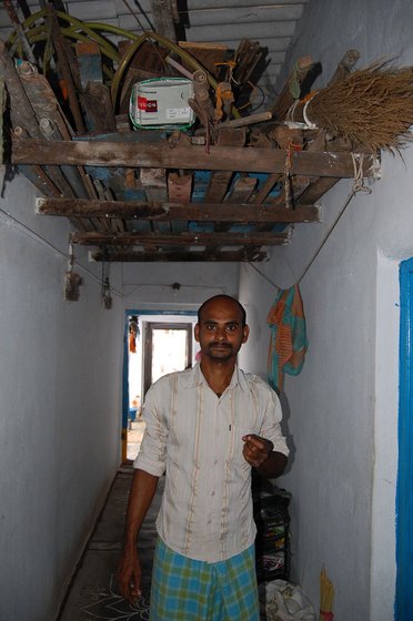 Right: Napa Kumar stands beneath the attic in which his loom lies packed away