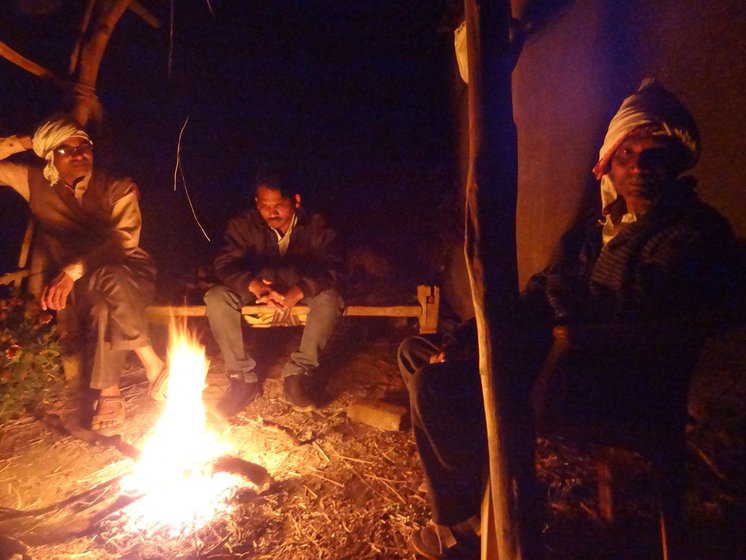 Dadaji (left) and Ramchandra lit a bonfire to keep warm on a cold winter night during a night vigil
