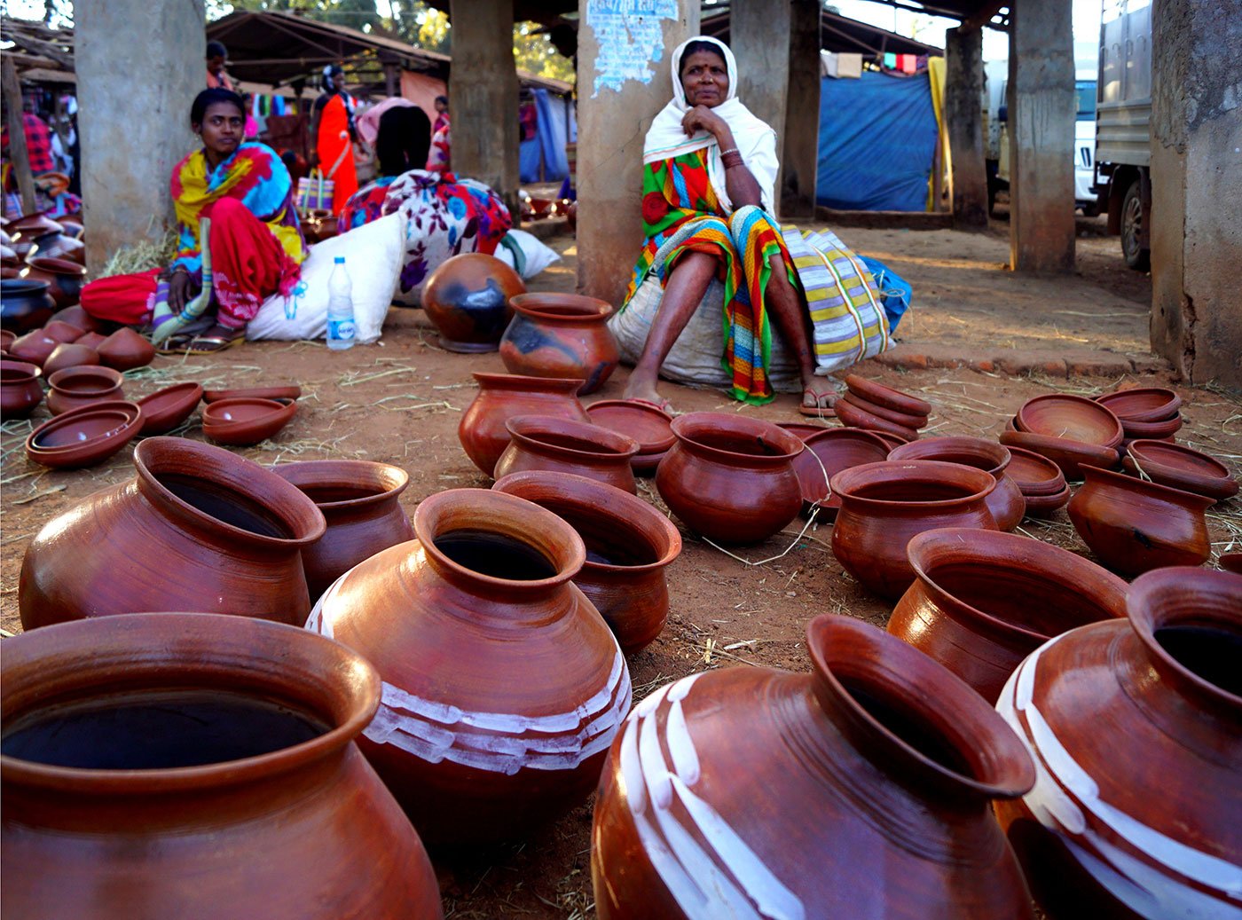 Two women wait with their pots for customers