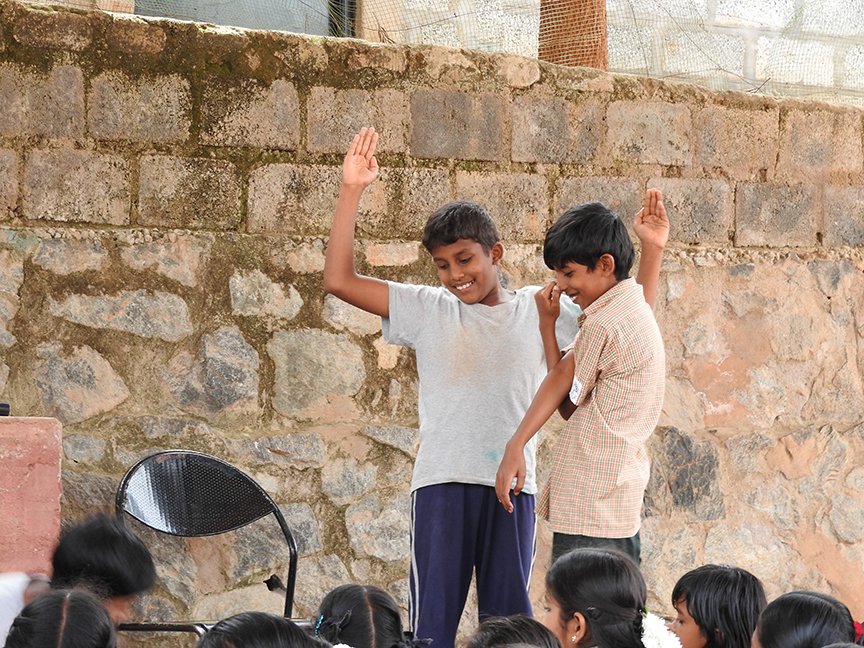 Meanwhile, the older students gather on stage for the daily assembly. Today is 'Comedy Day' and whoever has something prepared or wants to improvise is given time to do so. These two boys enact a short skit on ‘The elephant and the tree’ 