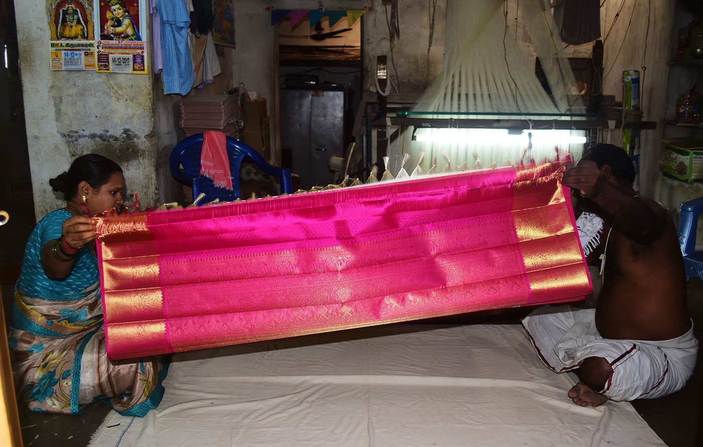 Devasenathipathi Kothandapani (another weaver by same name) and his wife Gomathi pack the finished saree into a box. The weavers have to deliver the neatly folded and boxed sarees to the cooperatives they are associated with