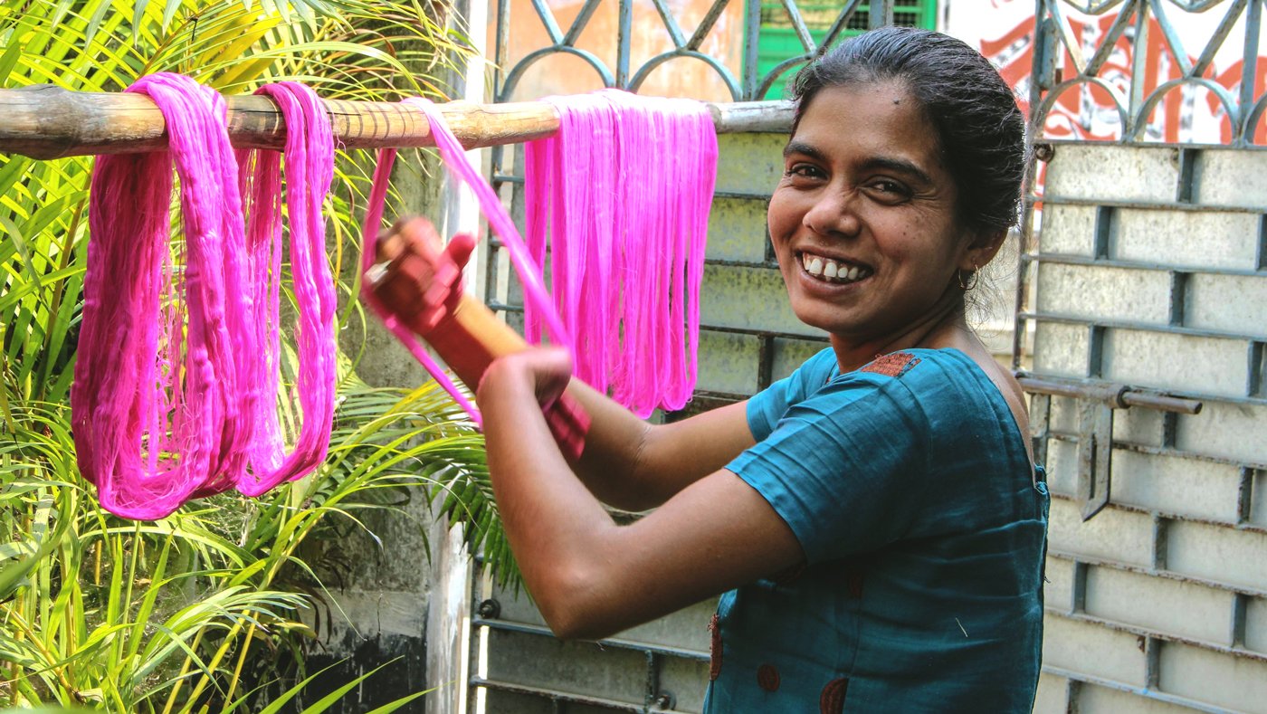 Woman drying coloured yarn