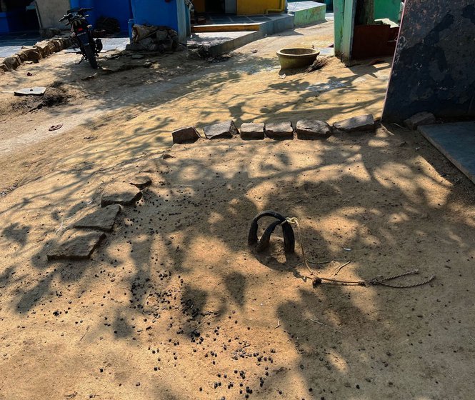 Narsamma indicates the spot marked with rocks (left), where a toilet was to be built three years ago by local officials, but nothing has happened. 'There are no toilets in this SC colony, not even a drain’