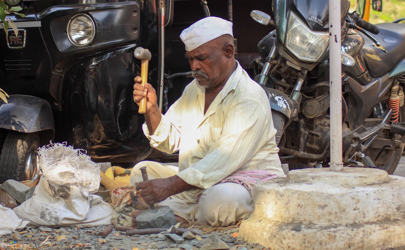 a man is hammering a stone to give it a shape