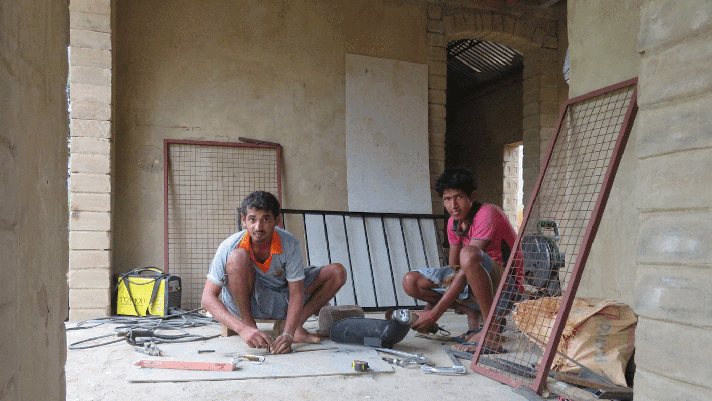 Young men installing window grille