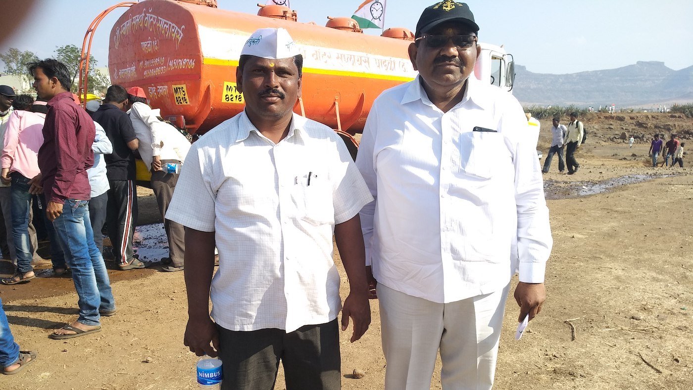 Farmers standing in front of a tanker