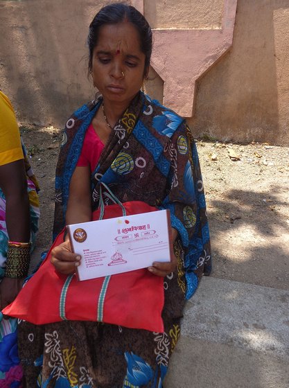 Sunita Jadhav shows her daughter's wedding invitation