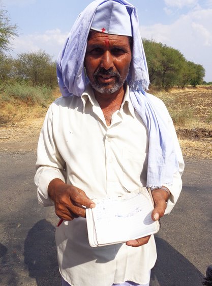 Farmer showing his diary with all loan entries
