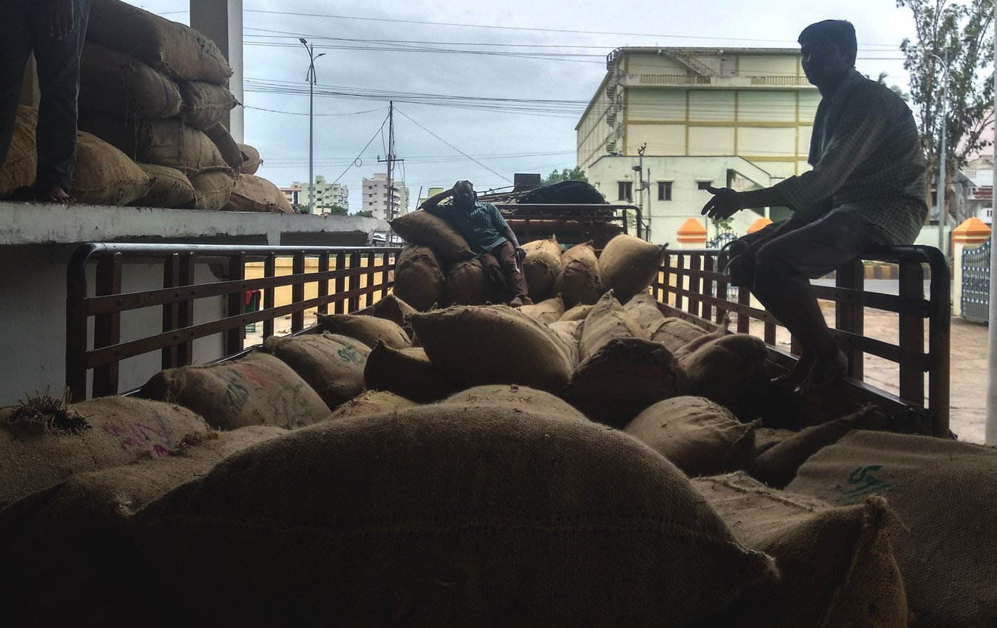 workers seating in a truck of loaded sacks of mirchi