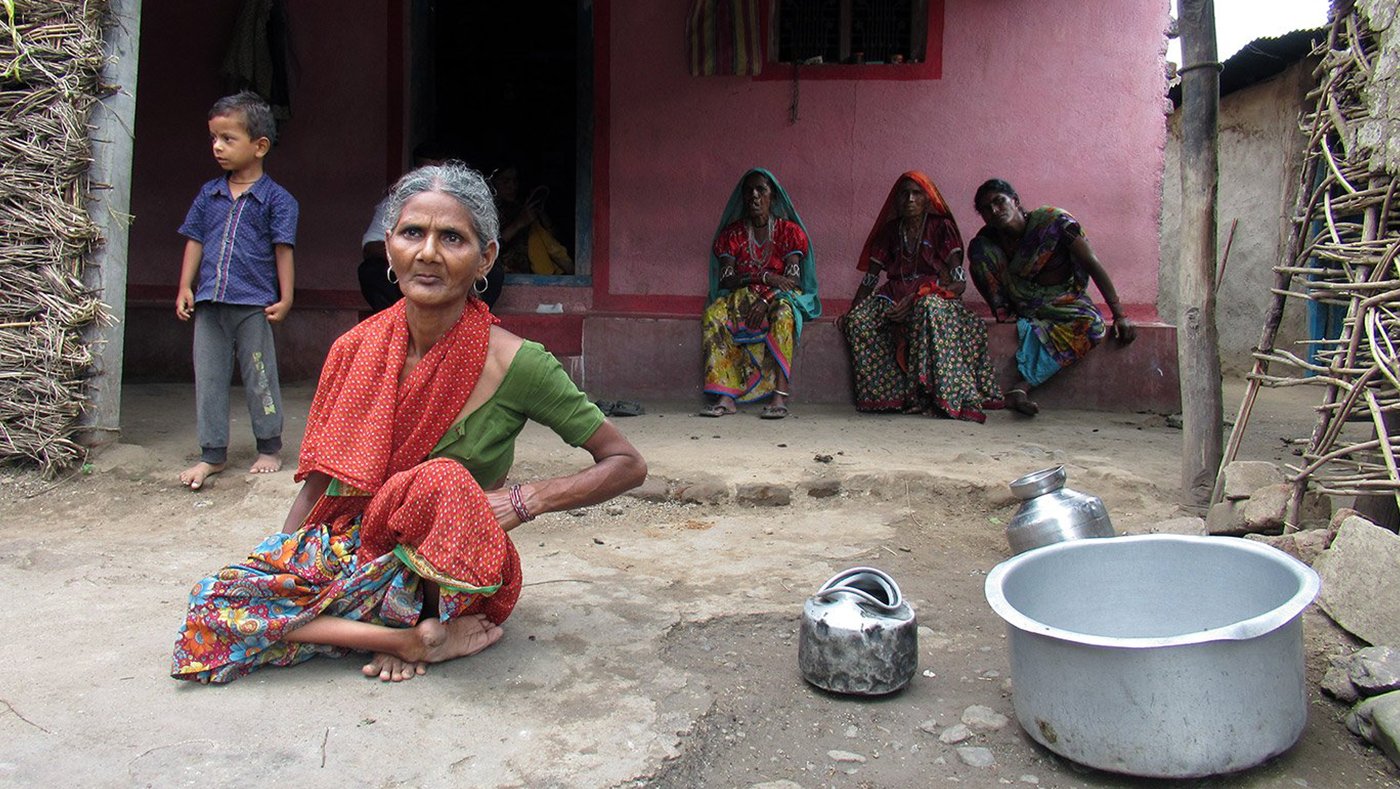 Old woman with her family with empty vessels