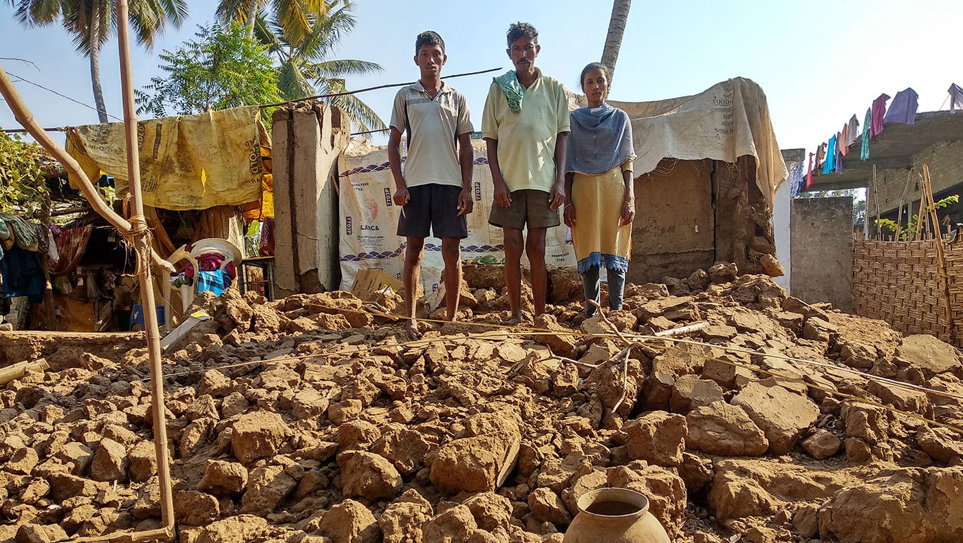 Bapiraju, his son Mutyala Rao and his daughter Prasanna Anjali stand on the top of the ruins of their house which got collapsed during the floods