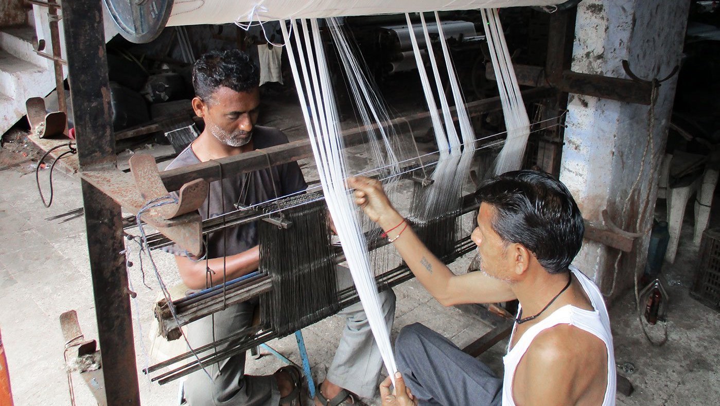 Two men working at a power loom