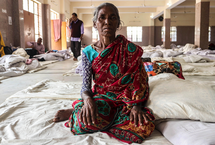 Old woman sitting on makeshift bed