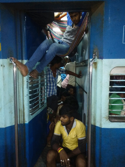 men sitting and hanging in the train. 