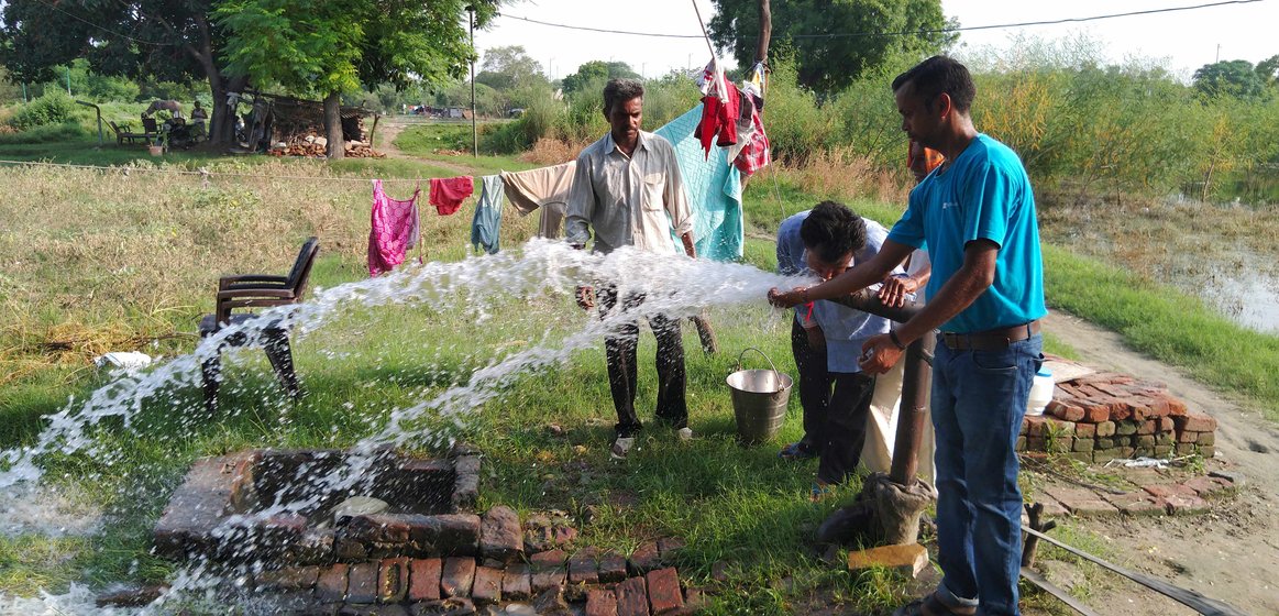 Shiv Shankar and his son Praveen Kumar start the watering process on their field