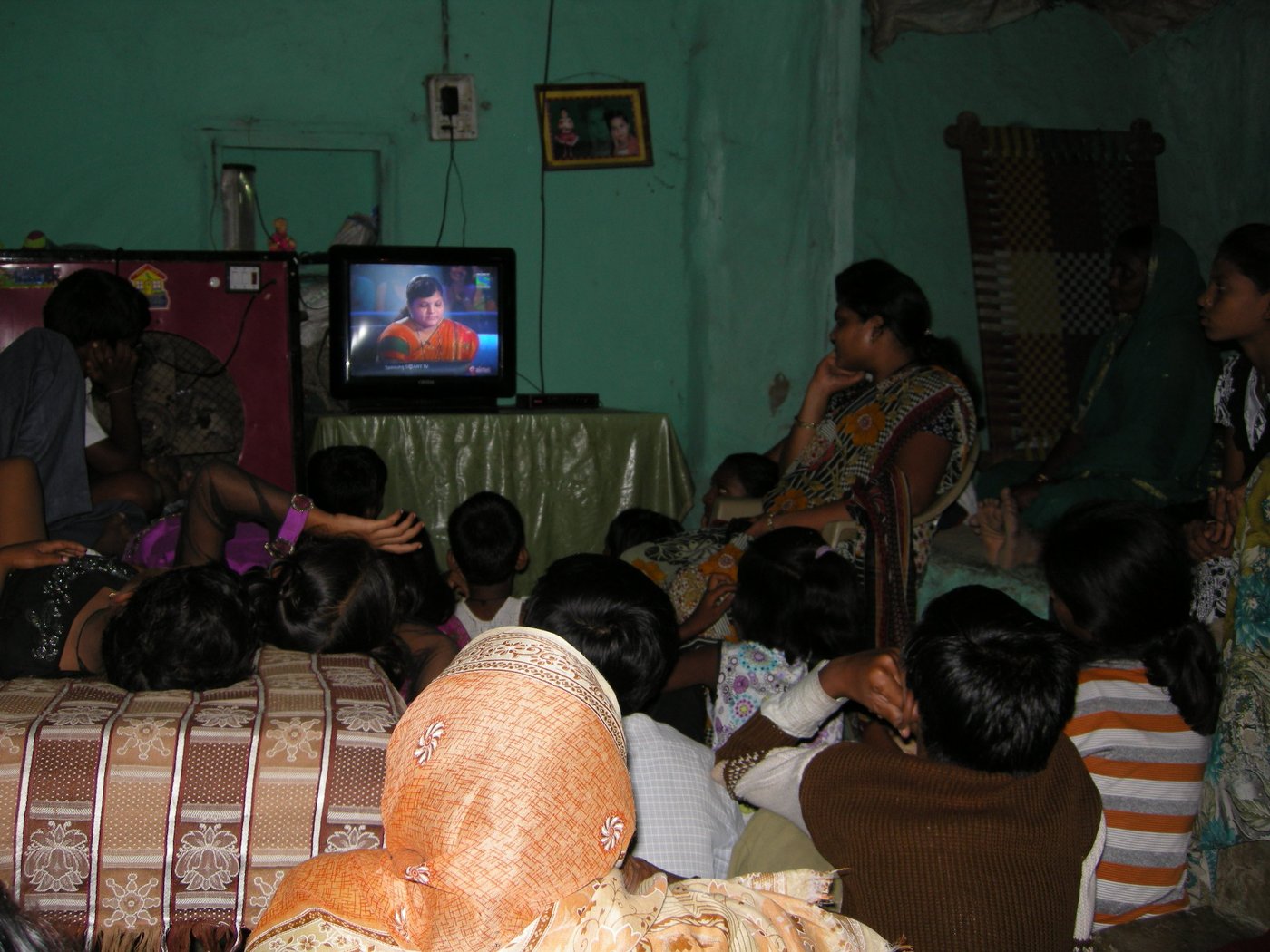 A group of people watching Kaun Banega Crorepati on television 
