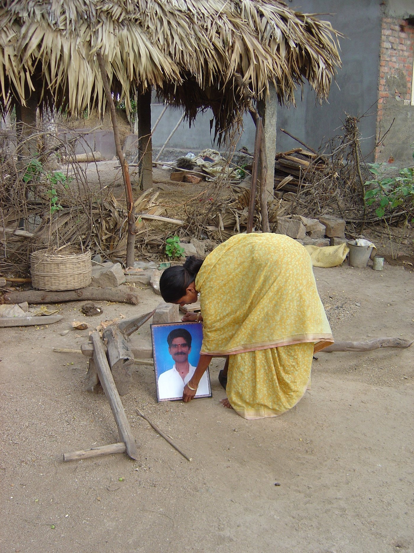 Woman putting her husband's photo on the ground