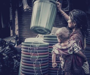 Woman with baby holding plastic bucket
