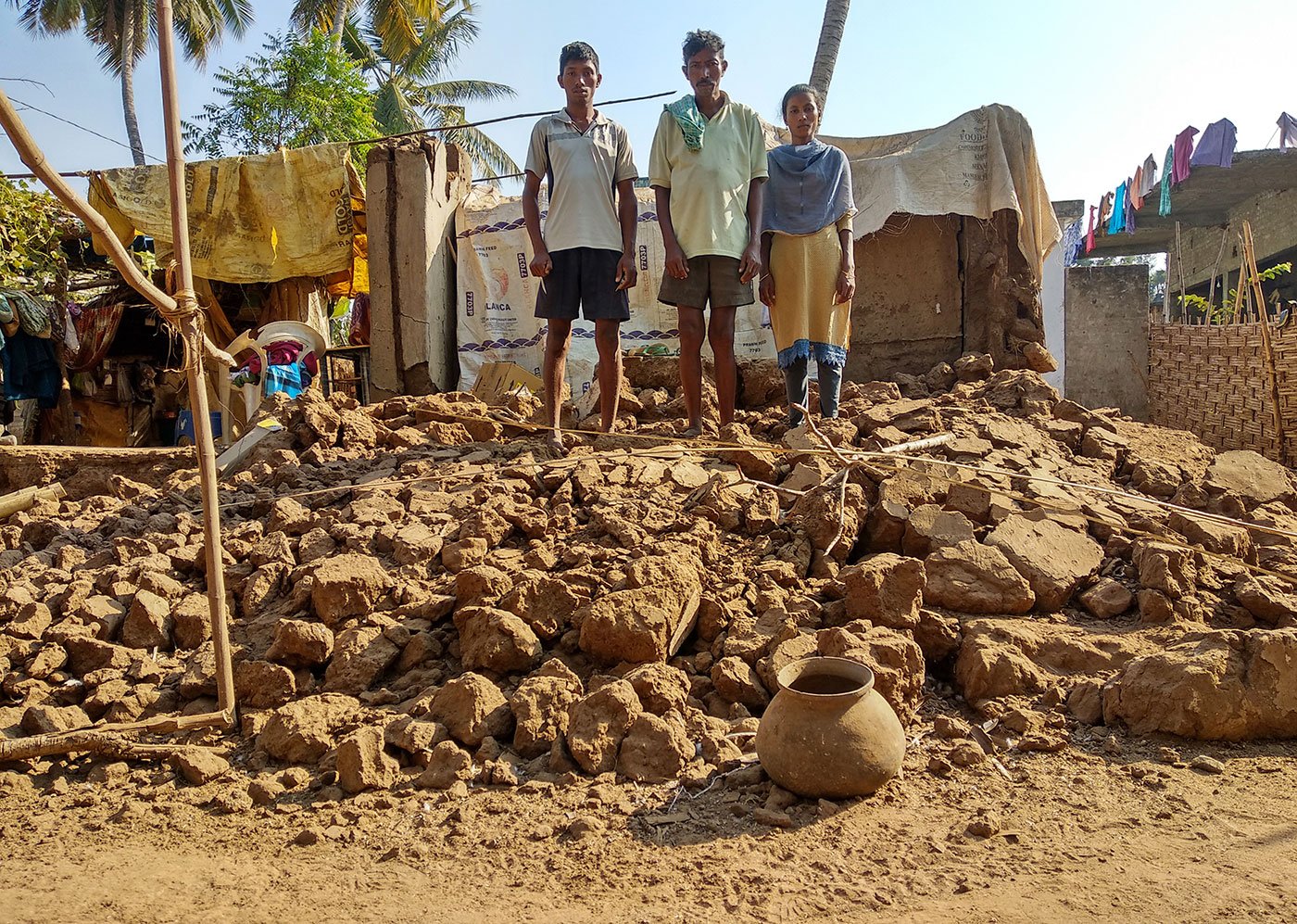 Bapiraju, his son Mutyala Rao and his daughter Prasanna Anjali stand on the top of the ruins of their house which got collapsed during the floods