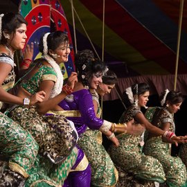 Women in saris dancing on a stage at a tamasha performance