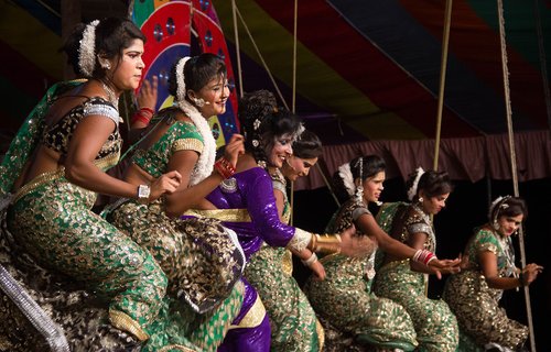 Women in saris dancing on a stage at a tamasha performance