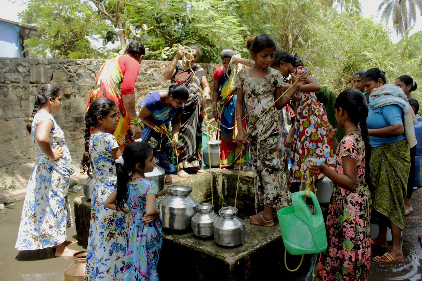 Women and young girls drawing water from well