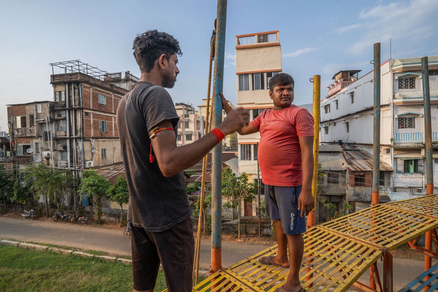 The riders are also the ones setting up the well-like structures. Here Pankaj Kumar (left) and Rubel Sheikh (right) are working on the set-up for a mela for Durga Puja in October 2023 in Agartala, Tripura