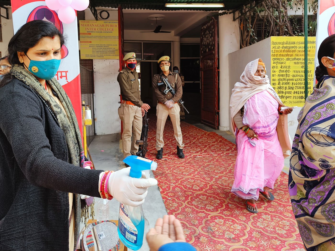 Reeta Bajpai spraying sanitiser on a voter's hands while on duty in Lucknow Cantonment assembly constituency on February 23