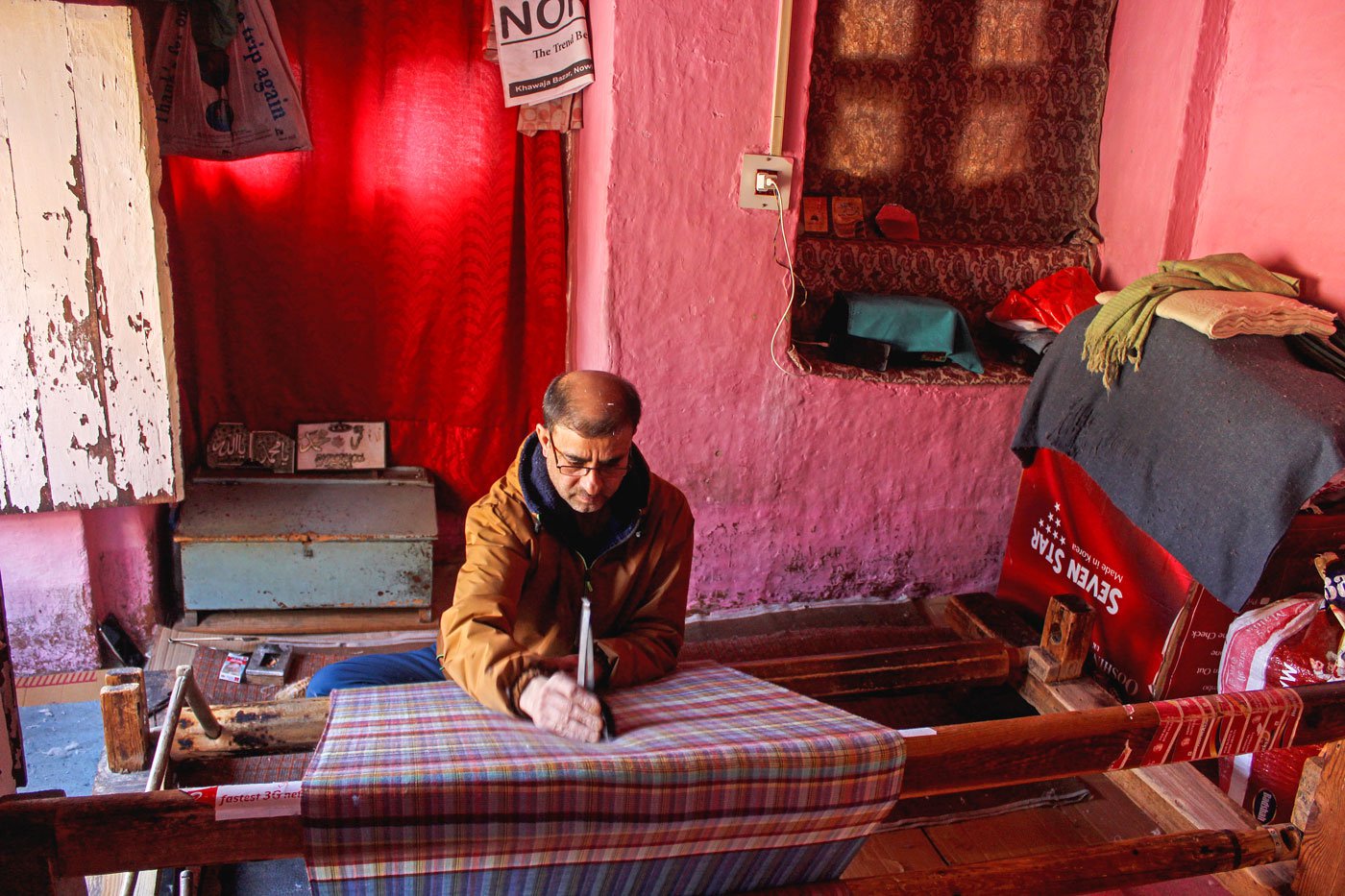 Abdul Majeed Lone works on a pashmina shawl tautly stretched across the wooden loom in front