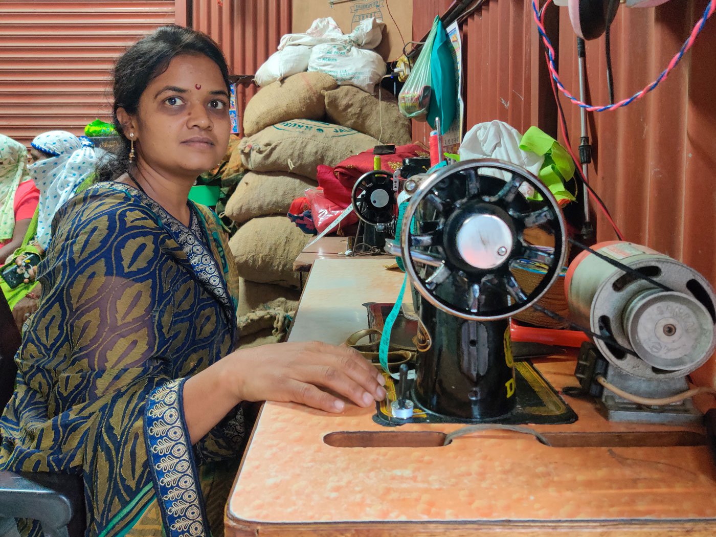 Shahbai Gharat at her sewing machine at home in Sultanpur village. Her work as an ASHA put her family at risk in May