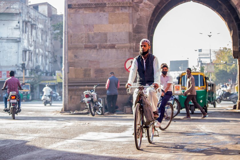 Left: Sameeruddin Shaikh cycling through the old city to Taj Envelopes in Khadia.