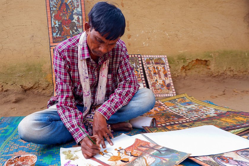Left: Vijay Chitrakar working on a Paitkar painting outside his mud house in Purbi Singhbhum district's Amadobi village