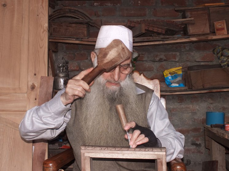 Ghulam Nabi Dar carves a jewelry box (right) in his workshop at home