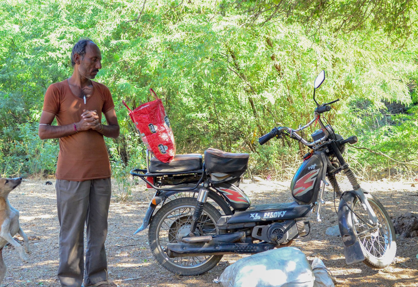 Jhujaram Dharmiji Sant with his moped and the sack of food on the ground