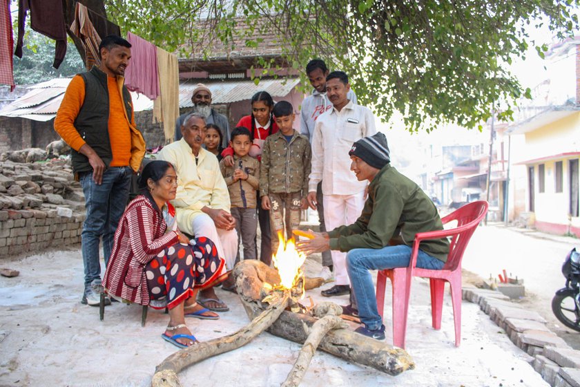 Left: Ajay Saini (on a chair in green jacket), and his wife, Gudiya Saini chatting around a bonfire in December. They share a common courtyard with the Qureshi family. Also in the picture are Jamal, Abdul Wahid and Shabbir Qureshi, with the Saini’s younger daughter, Sonali (in a red sweater).