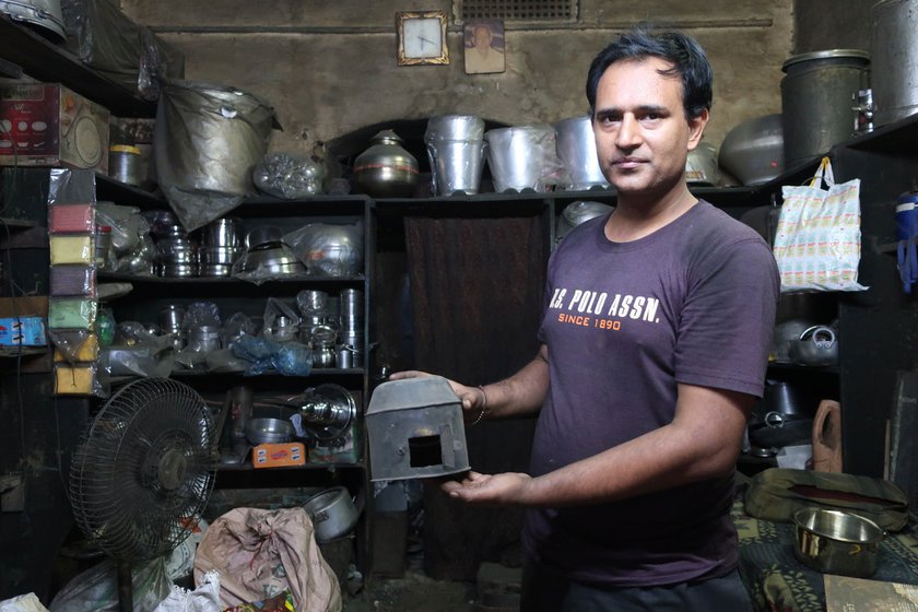 Sunil Kumar shows an old brass item that he made