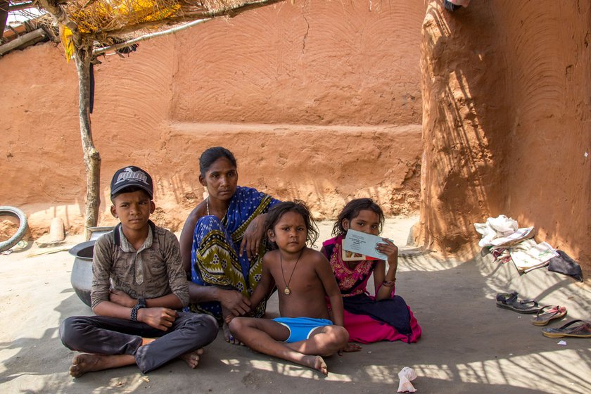 Namani Majhi sitting with her children in front of their house in Hial village in Balangir district.