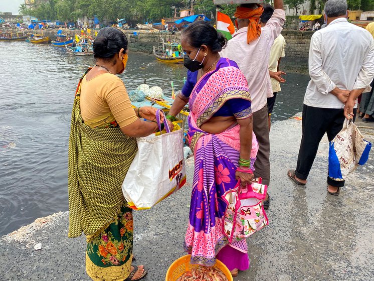 Vandana Koli and Gayatri Patil waiting for the boats to come in at Sassoon Dock. Once they arrive, they will begin determined rounds of bargaining