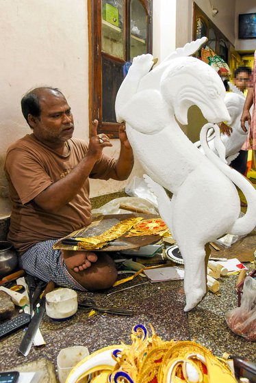 Left: Upendra working on a lioness carved from sholapith