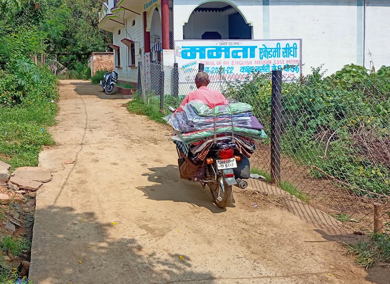 Bachu (with his son Puspraj on the left) visits 9-10 villages across 30 to 50 kilometres on his motorcycle t o sell sarees, chatais and other items