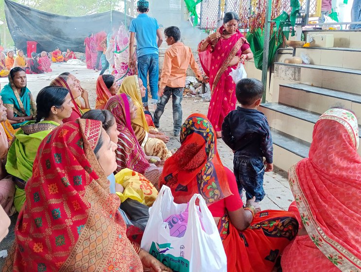 Right: Women sit outside the mazar, near the steps  to watch and seek blessings; their heads covered with the end of their sarees as they would in any temple