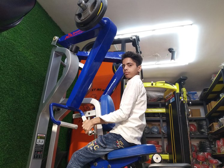 Right: Uzaif Rajput, a helper in the showroom, demonstrating how a row machine is used