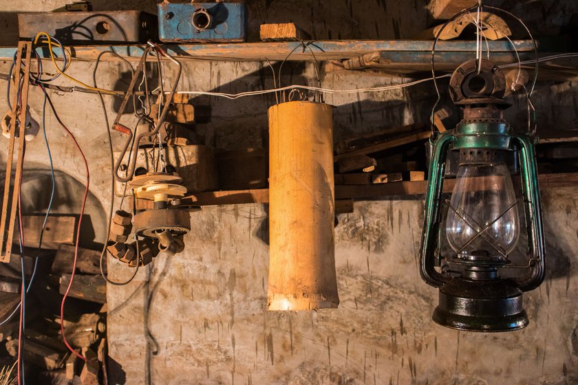 Among the array of traditional equipment and everyday objects at the workshop is a kerosene lamp from his childhood days