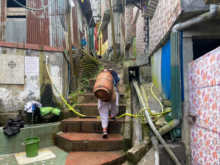Maya Thami climbs 200 stairs to deliver the day's first gas cylinder. Like other porters, she migrated from Nepal to work in Darjeeling, West Bengal
