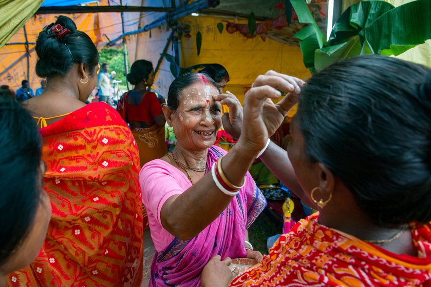 Left: Snake goddess Manasa is a popular among the Dalits of South 24 Paraganas as well as Bankura, Birbhum, and Purulia districts. On the day of Viswakarma Puja (September 17 this year) many households in remote villages in the Indian expanse of the Sundarbans worship the snake goddess and perform pala gaan.  Right: Older women in Rajat Jubilee village welcome others in the community to the Puja.