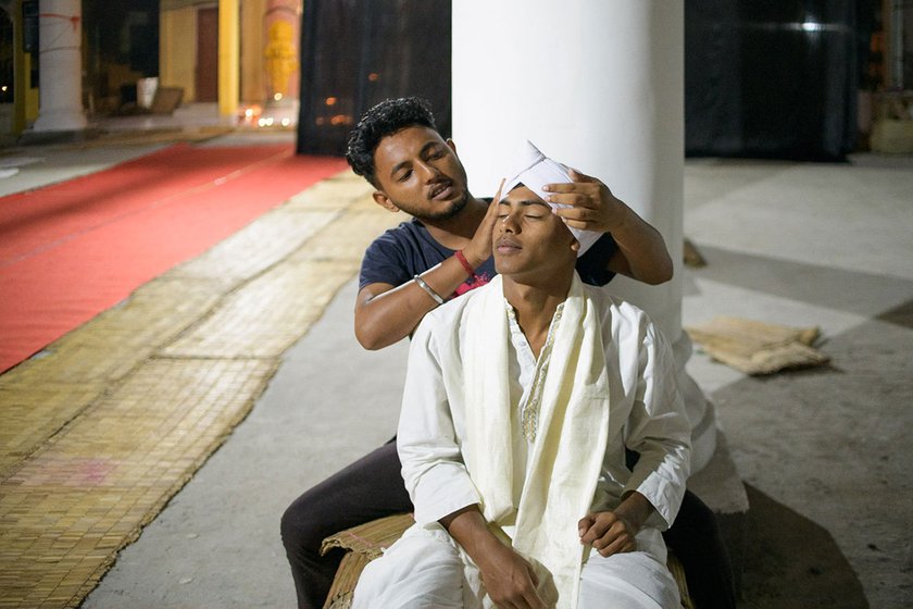 Right: Manash Dutta (in blue t-shirt) helps Subhashish Borah tie the traditional headgear called paag