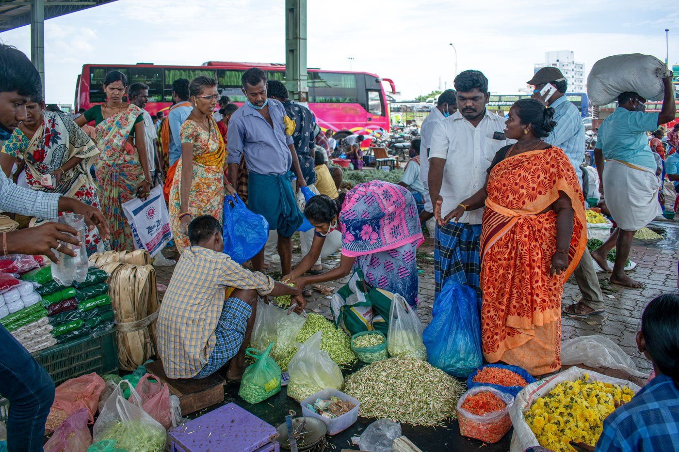 Retail vendors, mostly women, buying jasmine in small quantities. They will string these flowers together and sell them